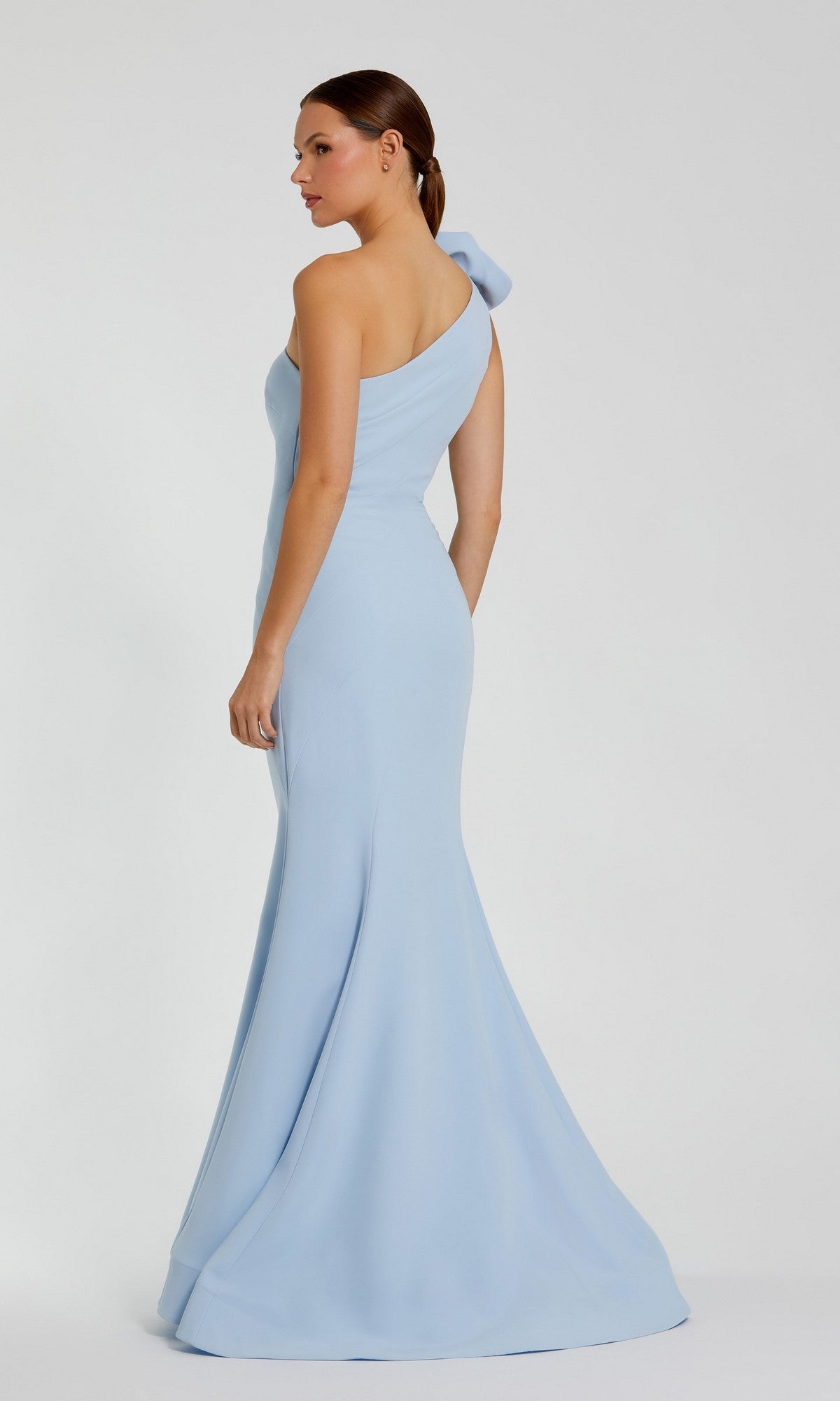 Woman wearing the Flower One-Shoulder Formal Dress: Mac Duggal 2304 in light blue, featuring a fitted bodice and flared mermaid skirt, standing against a plain light background.